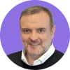 Portrait of a man in a sweater with a purple background.