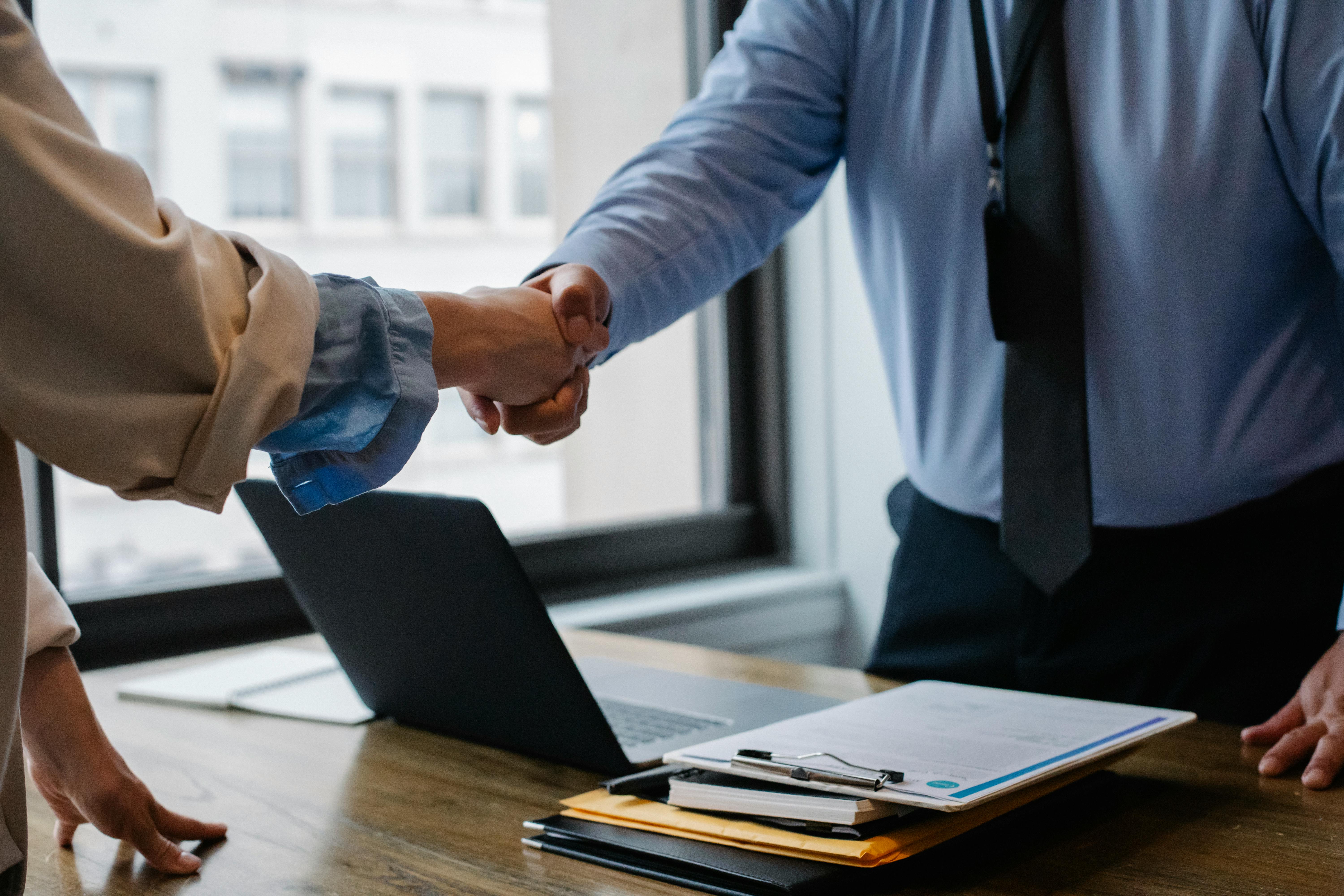 Crop colleagues shaking hands in office. Photo by Sora Shimazaki via Pexels. 