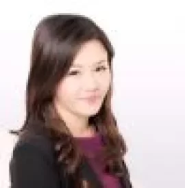 Portrait of a smiling woman with long hair in business attire.