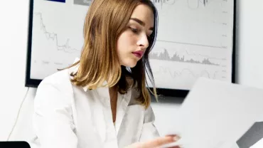 young female office employee looking at papers