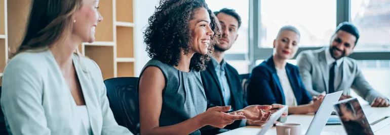 Five white-collar professionals of different genders and ethnicities seated in an office environment