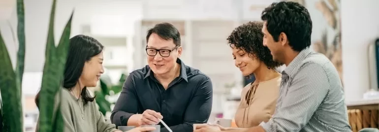 A gathering of people around a table, participating in a discussion and sharing insights in a group setting.
