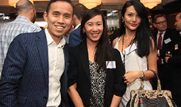 Group of three people smiling at a social event.