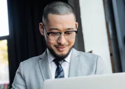 Executive smiling at his laptop