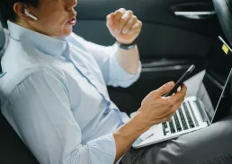 Executive working on his laptop in a car