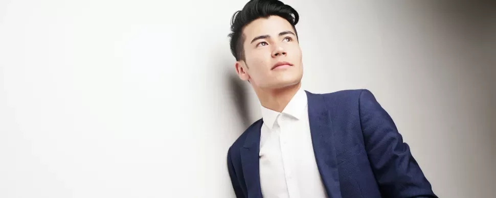 Man in a blue suit and white shirt looking away.