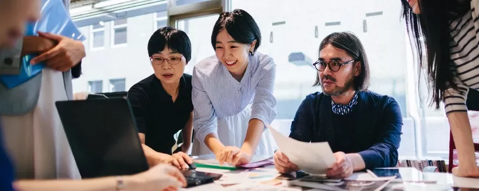 Group of people collaborating at a table in a modern office.