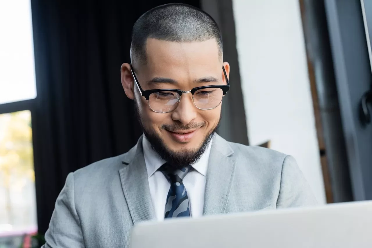 Executive smiling at his laptop