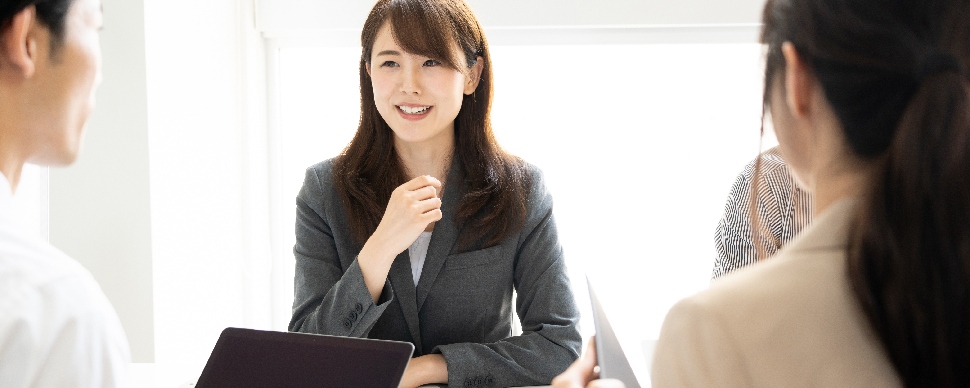 A female Asian professional in a face-to-face job panel interview with two other interviewers